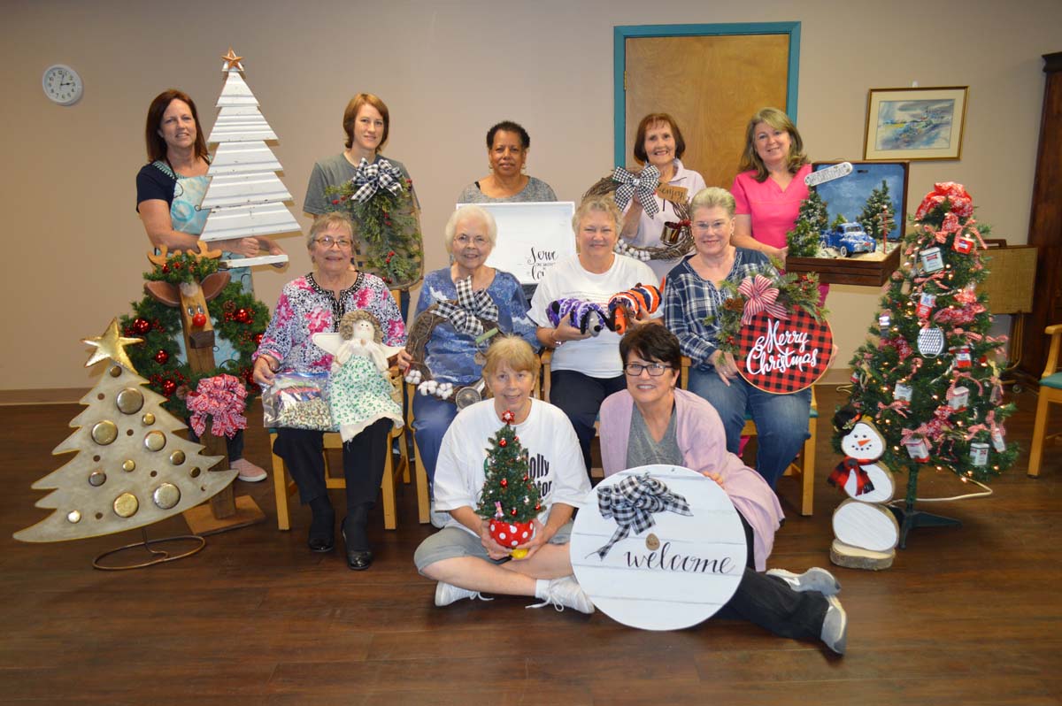 Several ladies pose for a photo with the crafts they made for the annual Christmas Bazaar.